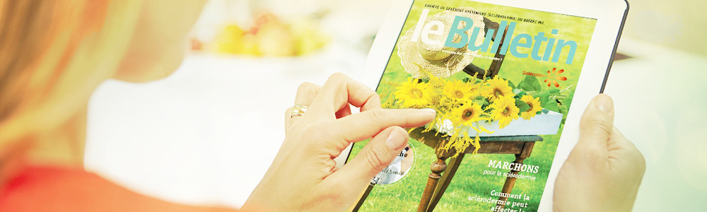 a woman reading the sclerodermie Quebec newsletter on a tablet PC
