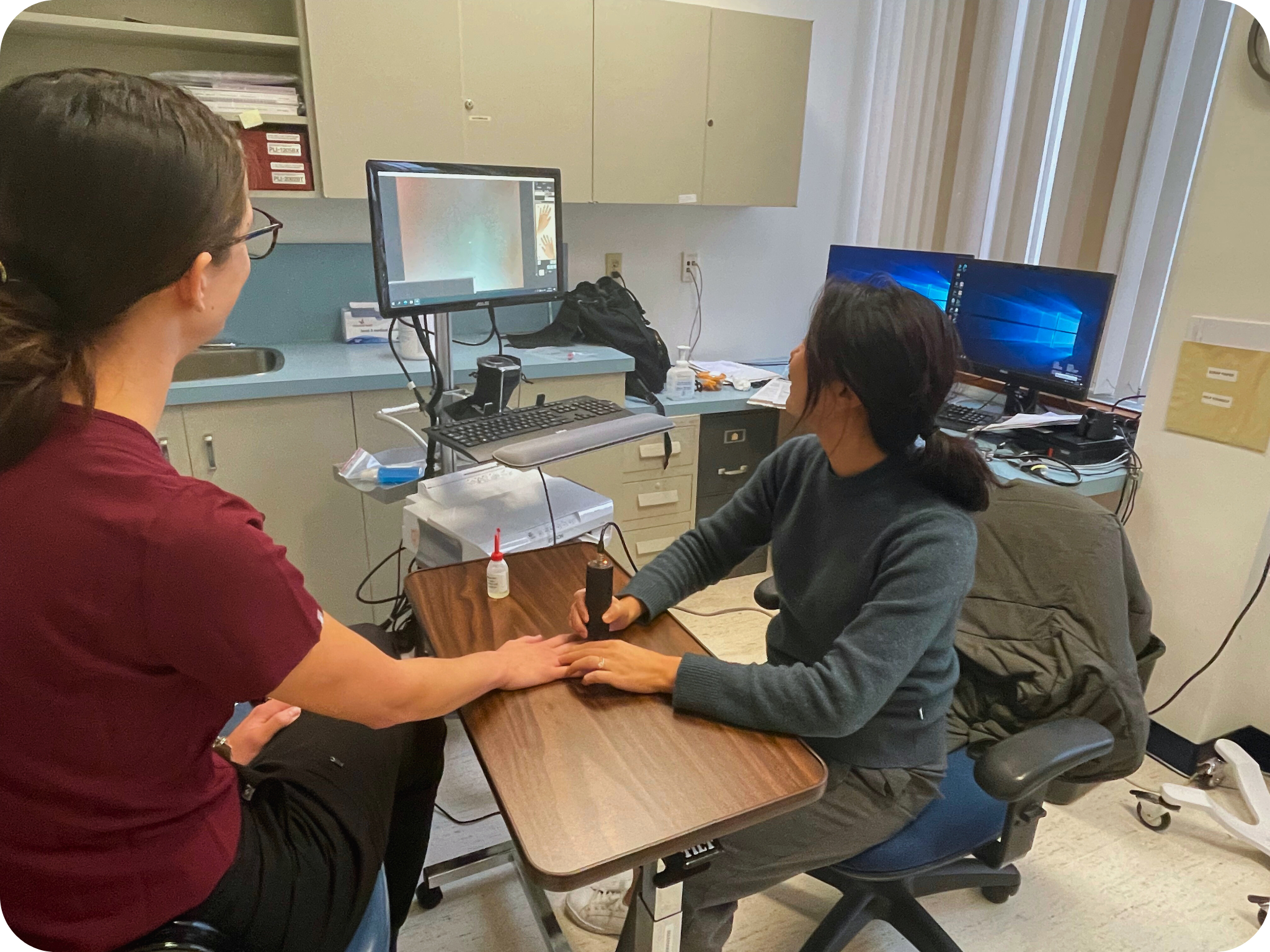 Dr Kim using a non-invasive imaging tool called nailfold video capillaroscopy (NVC) to detect early signs of scleroderma